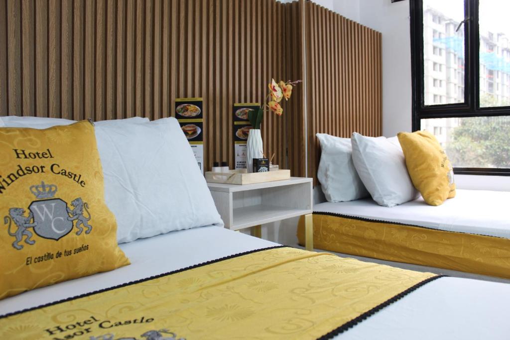 sypialnia z 2 łóżkami z żółtymi i białymi poduszkami w obiekcie Hotel WC w mieście Bogota