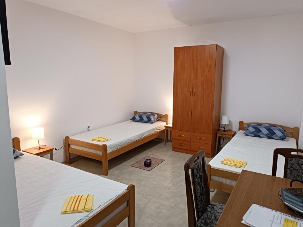 Cette chambre comprend 2 lits et une armoire en bois. dans l'établissement Adamovic, à Pirot