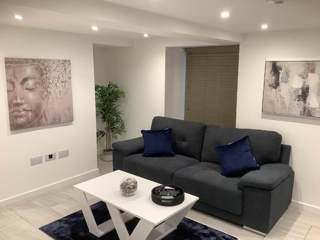 a living room with a couch and a table at Newly Renovated Apartment in Bicester