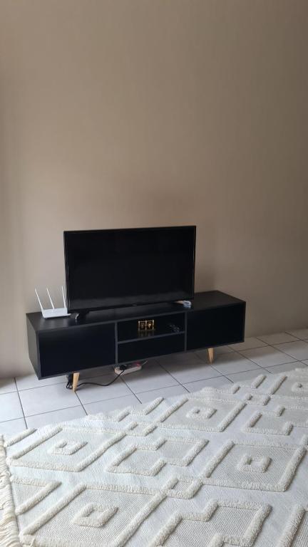 a living room with a flat screen tv and a carpet at NO LOADSHEDDING Two Bedroom Unit in Trichardt