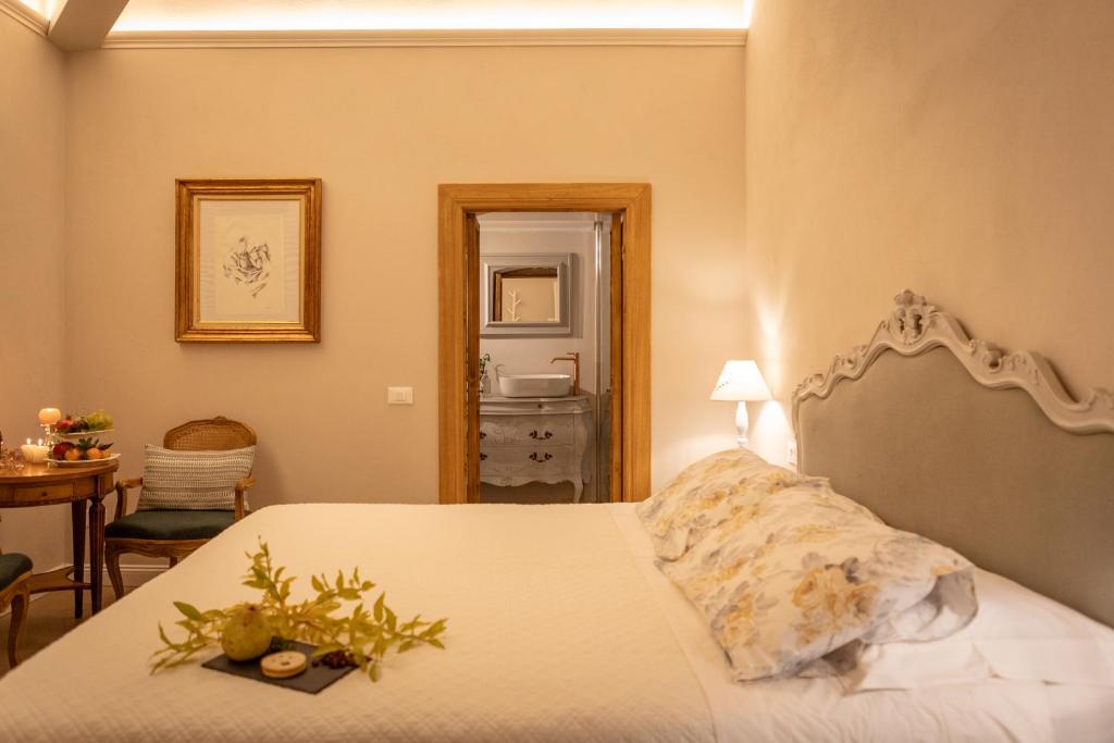 een slaapkamer met een bed, een tafel en een spiegel bij San Michele al Castello in Castiglion Fiorentino