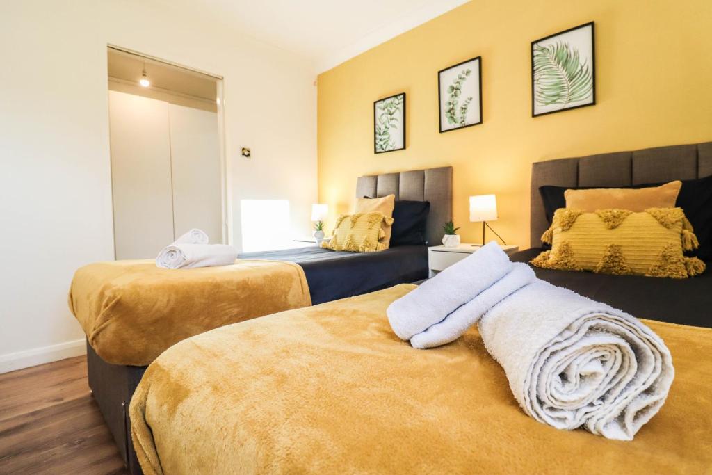 1 dormitorio con 2 camas y sofá en FREE Parking, 1 bedroom apartment close to HEATHROW en Stanwell