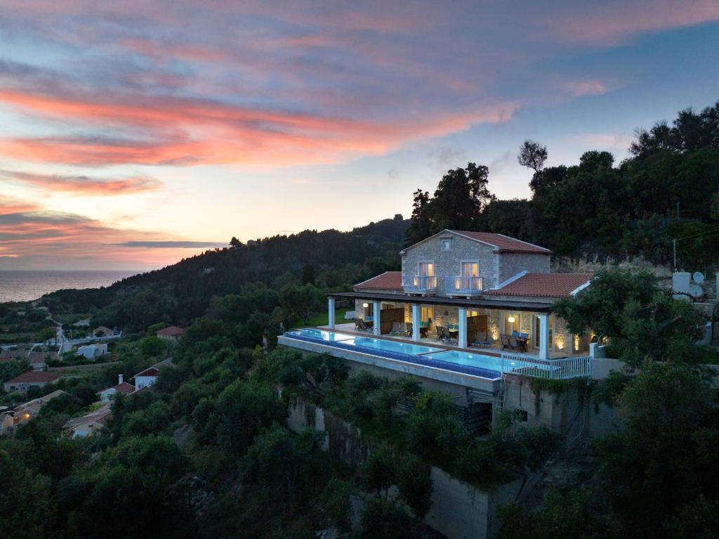 a house on top of a hill with the sunset at Bella Vista Ereikousa in Ereikoússa