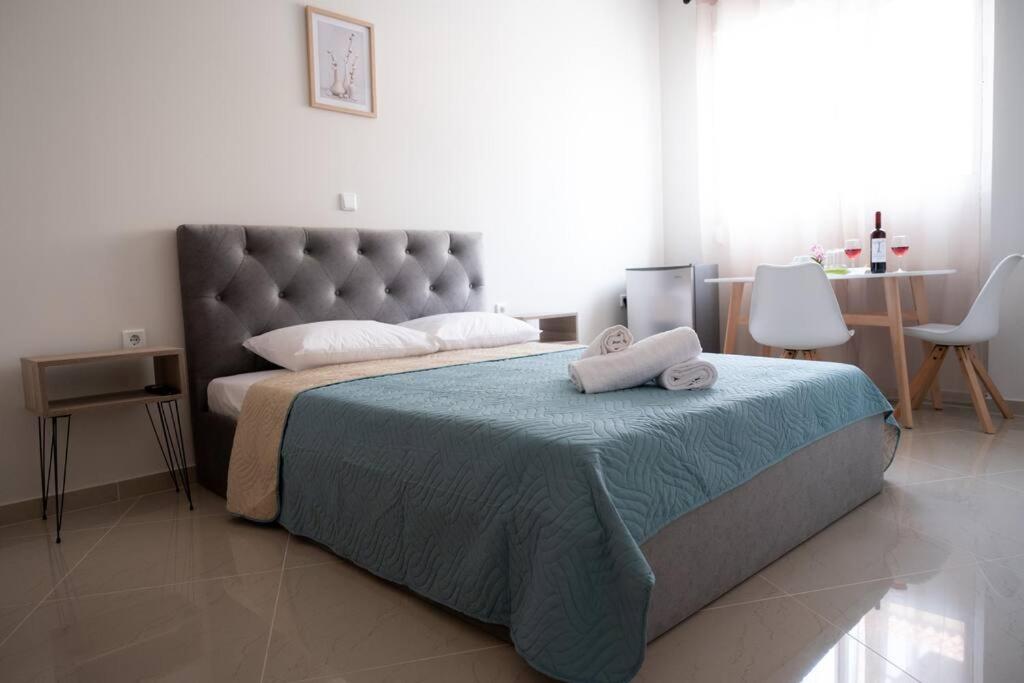 a bedroom with a large bed with two pillows on it at Anesis Airport rooms 102 in Koropíon