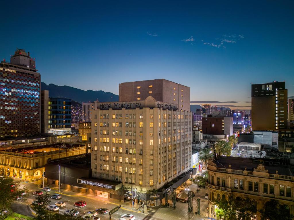 a tall building in a city at night at Hotel Monterrey Macroplaza in Monterrey