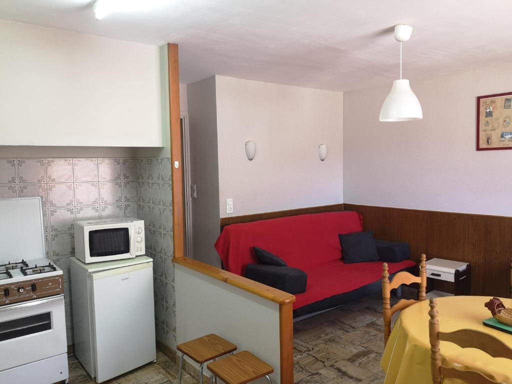 - une petite cuisine avec un canapé rouge dans une chambre dans l'établissement St Roch La Casalle - BOYER locations, à Ax-les-Thermes
