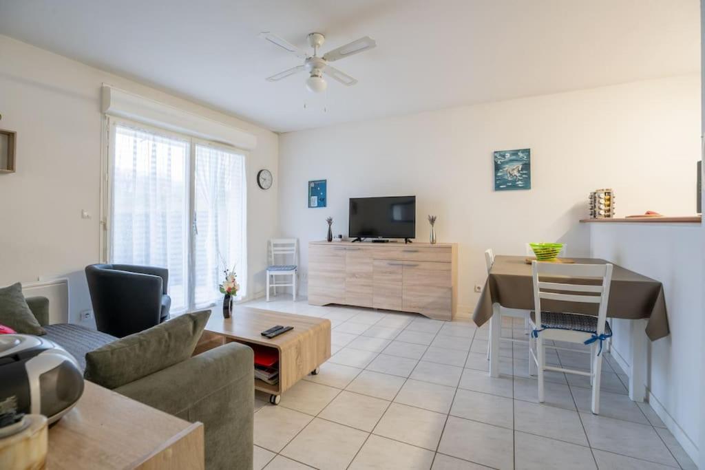 un salon avec un canapé et une table dans l'établissement Les clés de Jonzacconciergerie Carré des Antilles, à Jonzac