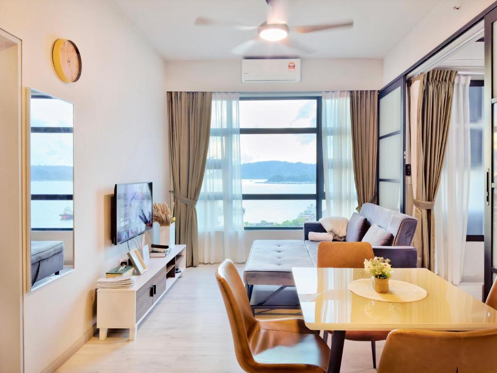 a living room with a table and a couch at #9 Jesselton Quay City Pads Seaview by Zeluxo in Kota Kinabalu