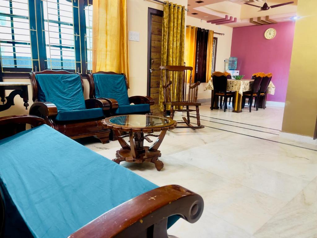 a living room with chairs and a table in a room at Prince Castle-4BHK Apartment,Guesthouse in Hyderabad