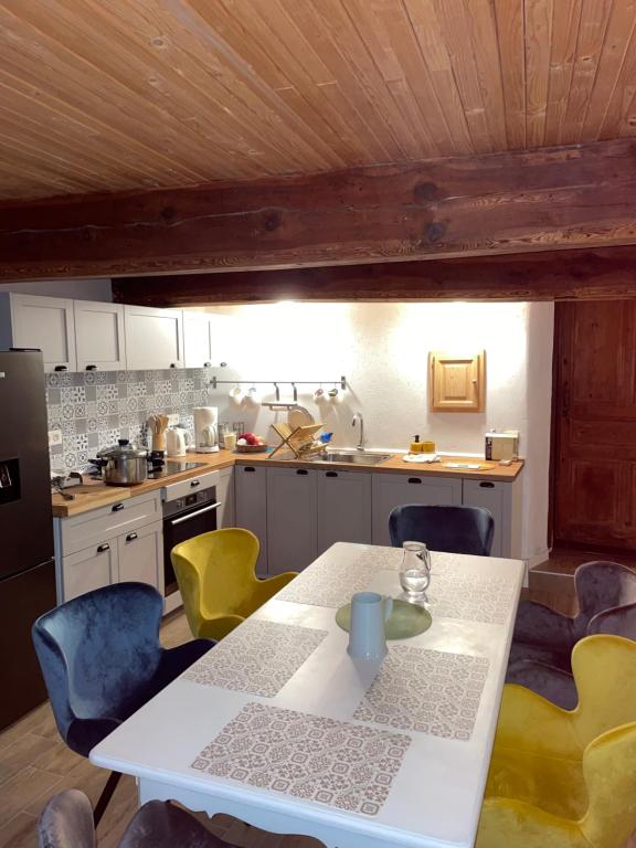 une cuisine avec une table blanche et des chaises jaunes dans l'établissement Appartement 5 personnes-1 chambre- Longefoy-Montalbert - La plagne, à Aime La Plagne