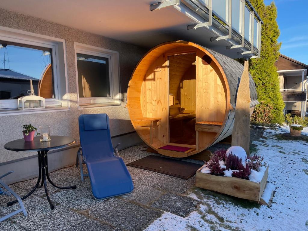 ein Haus mit einer Holztür, einem Tisch und einem Stuhl in der Unterkunft Ferienwohnung Elfengast, FassSauna, Harzurlaub in bester Lage in Bad Harzburg