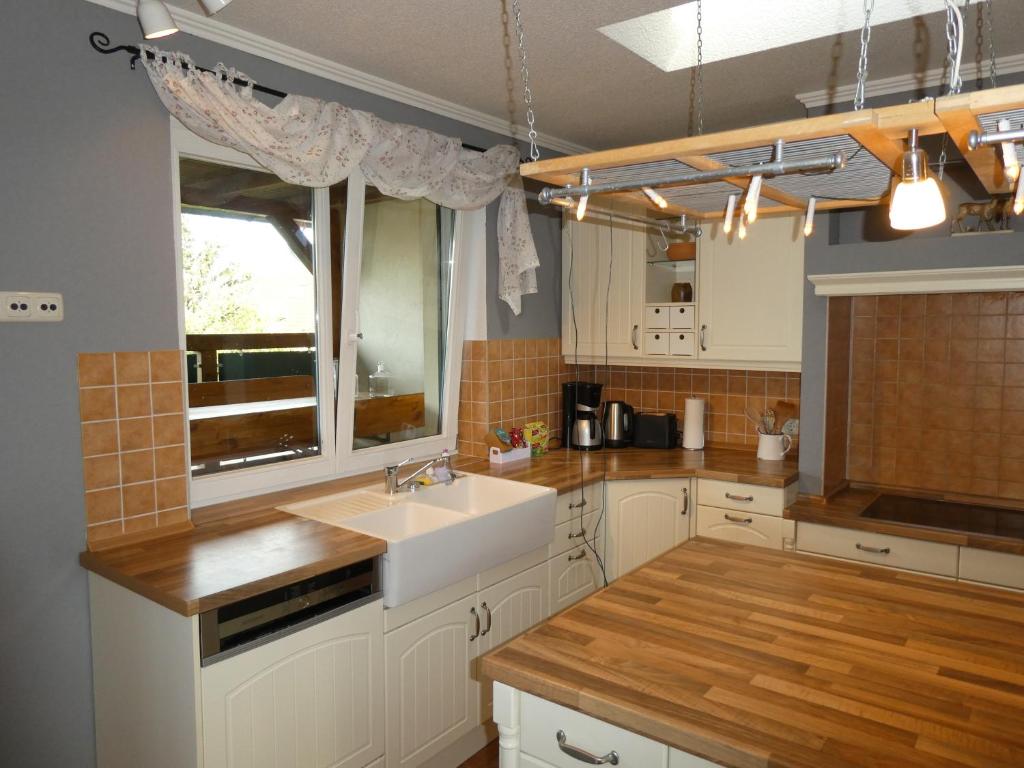 een keuken met witte kasten, een wastafel en een raam bij Familienurlaub mit Hund an der Ostsee in Admannshagen-Bargeshagen