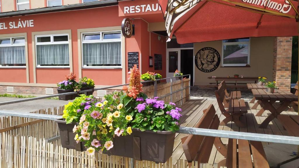 - un restaurant avec des fleurs à l'avant dans l'établissement Hotel Slávie, à Trhová Kamenice