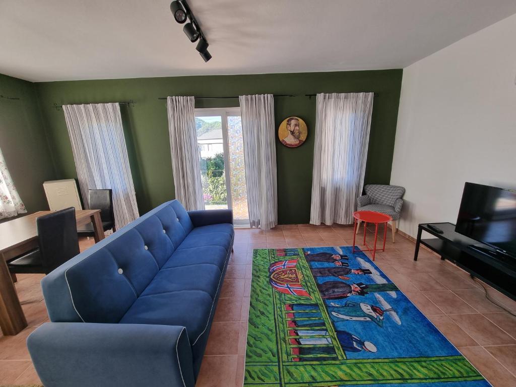 a living room with a blue couch and a television at Villa Xenia in Kemer