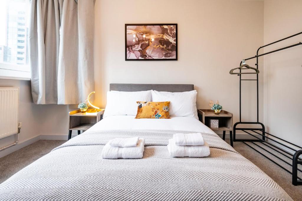 een slaapkamer met een groot bed en 2 handdoeken bij Lovely 4 bedroom flat in Wandsworth- London in Londen