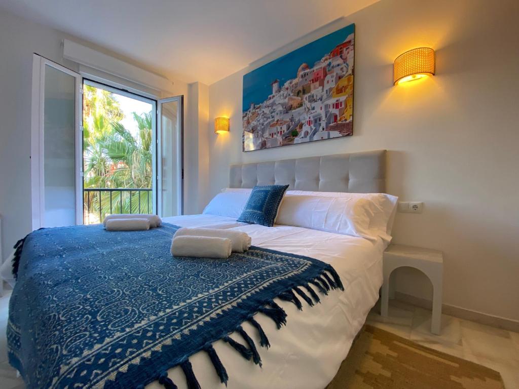 1 dormitorio con 1 cama con 2 toallas en Nomad Stays Milos y Bali, en Marbella