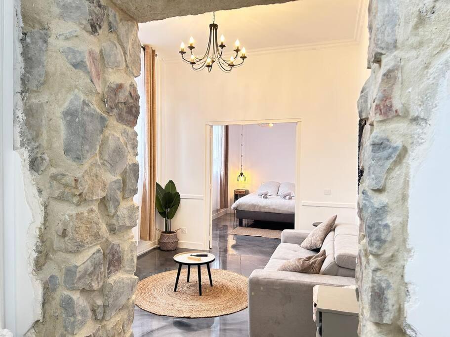 sala de estar con sofá y pared de piedra en Élégant*Epoxy*Design&Décor en Domfront