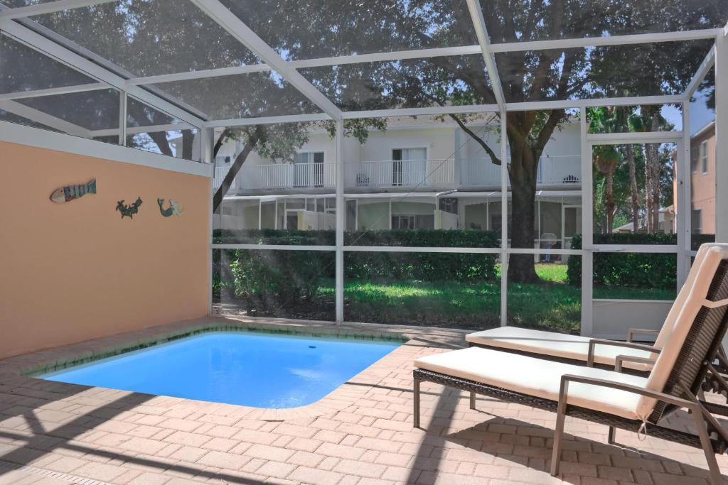 een patio met een zwembad en een stoel en een zwembad bij TR1411RC - 3 Bedrooms - 3 Baths - Pool - Patio in Orlando