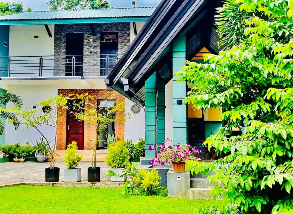 una casa con una porta rossa e alcune piante di Aura Villa a Polonnaruwa