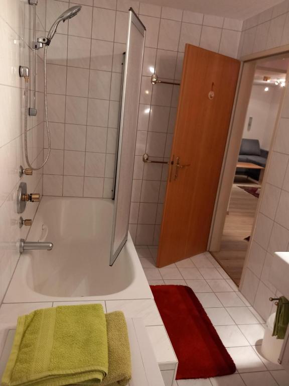 y baño con ducha y bañera con toalla verde. en Landhaus-Königsberg, Vorberg 360 en Ramsau am Dachstein