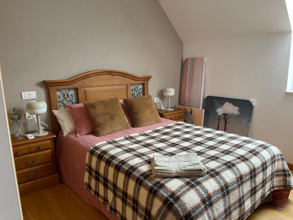 um quarto com uma cama grande e um cobertor xadrez em Apartamento con terraza (Morriña) em Sada