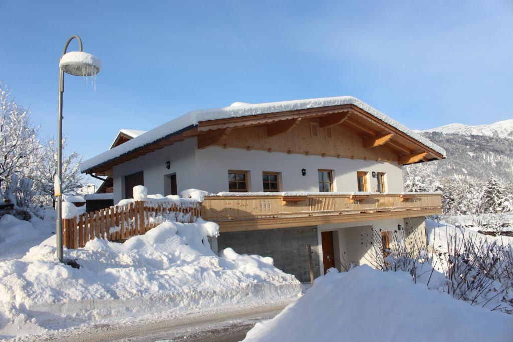 een huis bedekt met sneeuw naast een straatlicht bij Ferienhaus Weber-Häusl in Reith im Alpbachtal