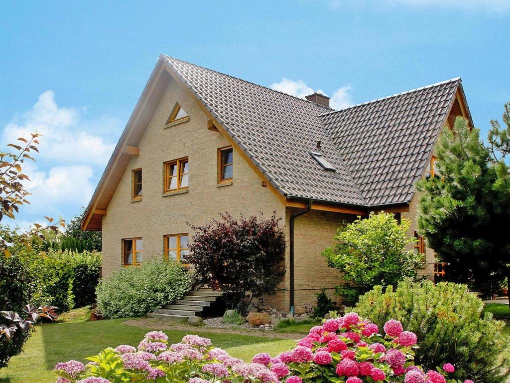 a house with a shingled roof and some flowers at Apartment house, Lütow in Lütow