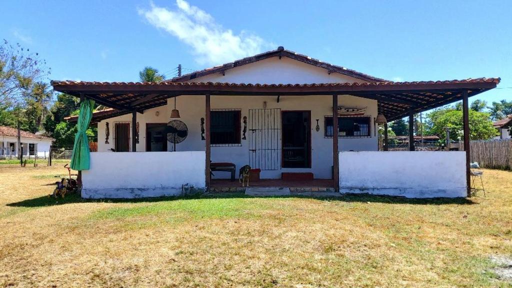 una pequeña casa blanca con techo en Casa em Soure Ilha de Marajó., en Soure