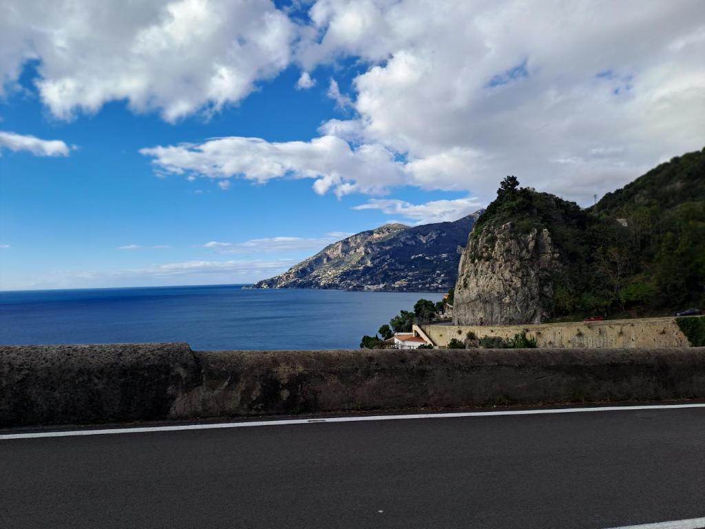 una carretera con vistas al océano y a la montaña en LA CASA DEL CAPITANO furore amalfi coast, en Furore