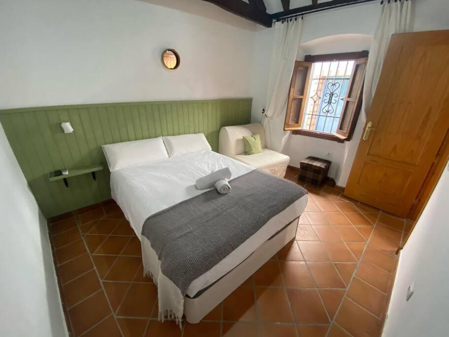 1 dormitorio con cama y ventana en Casita Gazul, en Alcalá de los Gazules