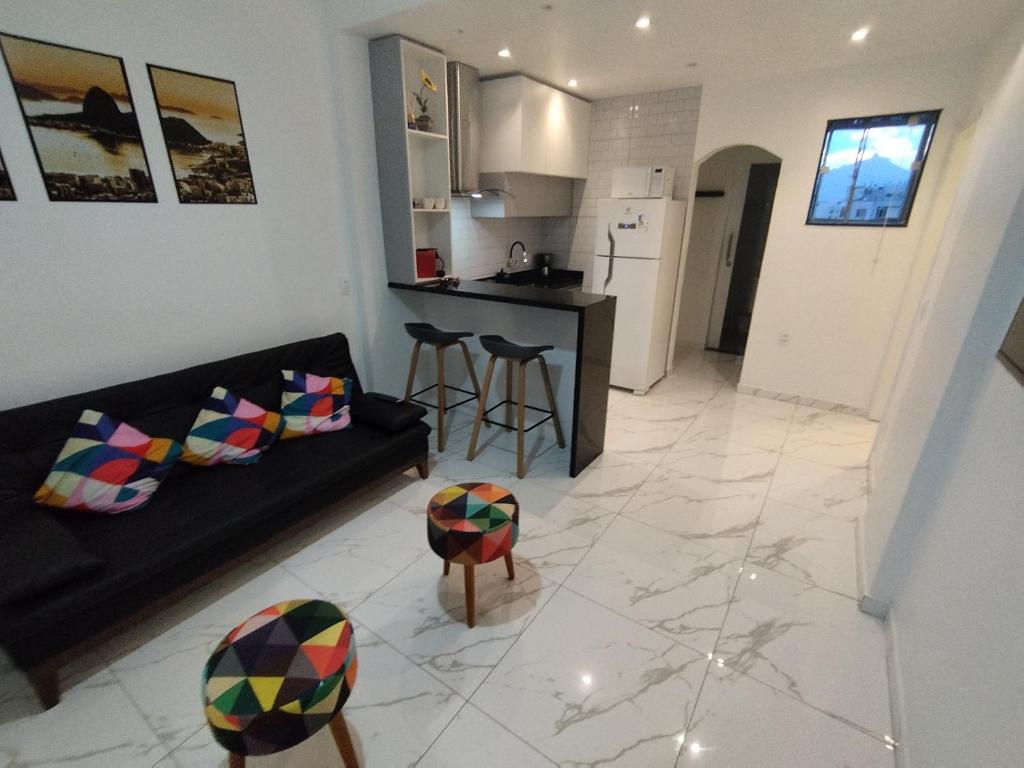 sala de estar con sofá negro y cocina en Lindo apartamento na Lapa, en Río de Janeiro