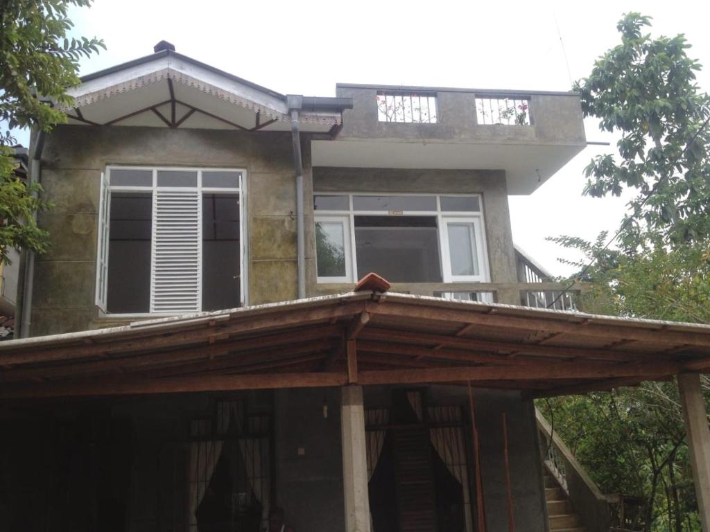 uma casa com uma pérgula de madeira em frente em MIST em Ambalangoda