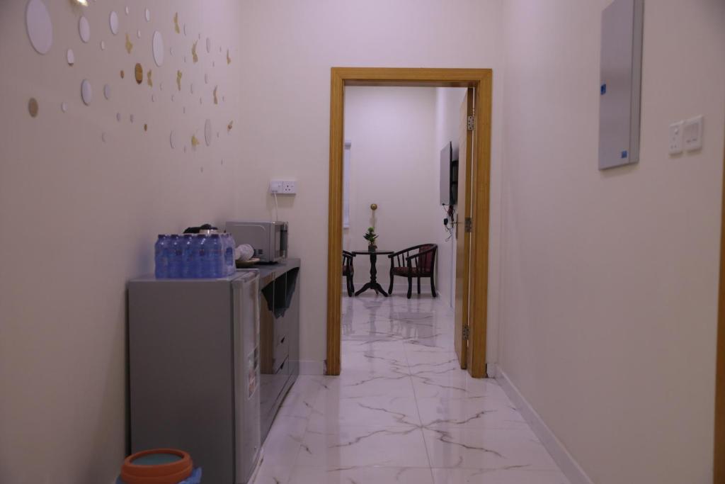 a kitchen with a refrigerator and a table in a room at شقق ريام جيزان للعوائل in Jazan
