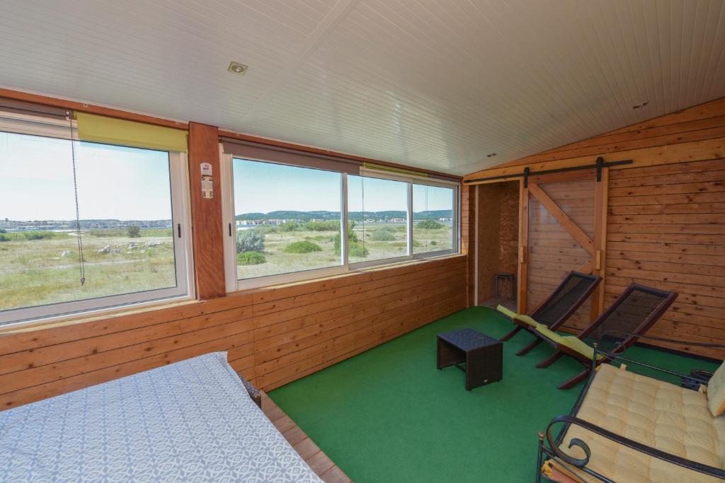 a room with two chairs and a table and windows at VENEZ SEJOURNER A GRUISSAN ....PLAGE DES CHALETS in Gruissan