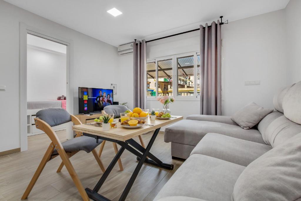 sala de estar con mesa y sofá en Gaia de SteraM Flats, en Torremolinos