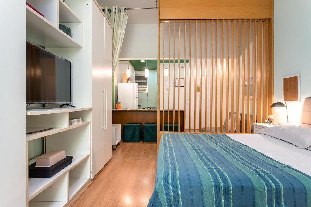 um quarto com uma cama e uma televisão num quarto em Studio SOL de COPACABANA 300 m da Praia no Rio de Janeiro