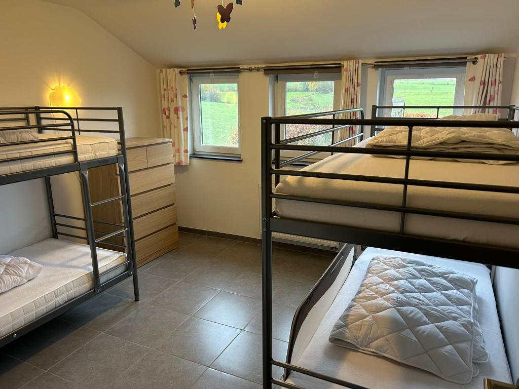 a room with three bunk beds and a window at Le Gîte du Vieux Chêne in Bertogne