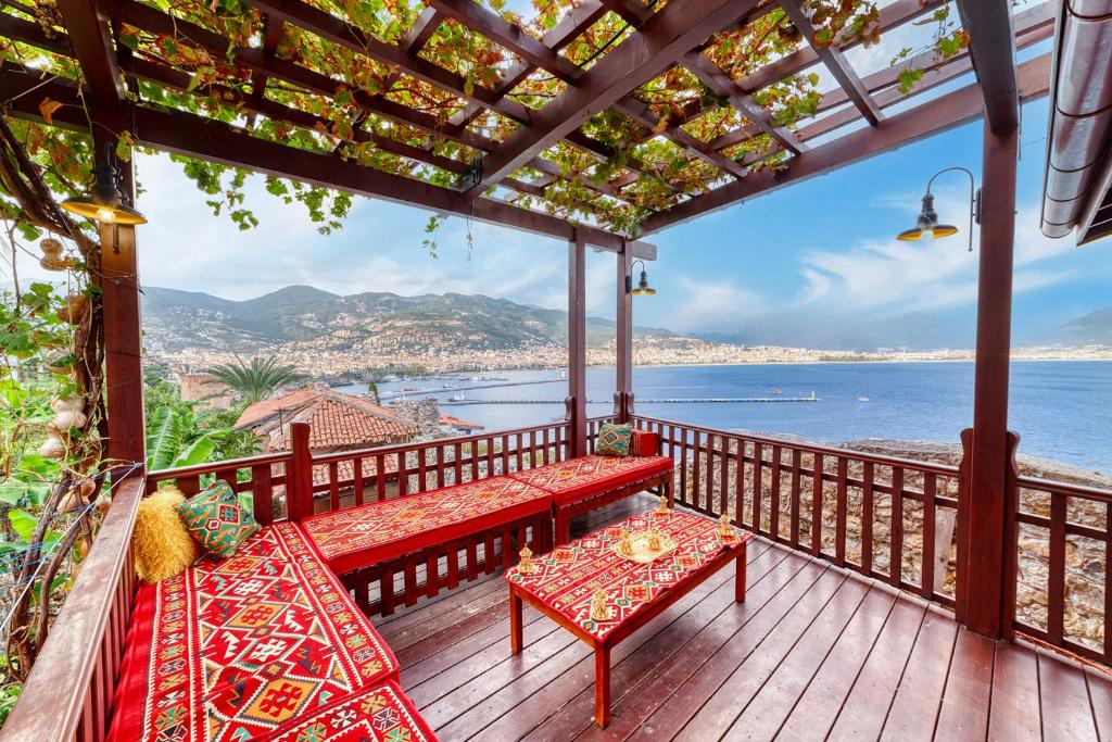 a porch with benches and a view of the ocean at The Sukabaği House in Alanya
