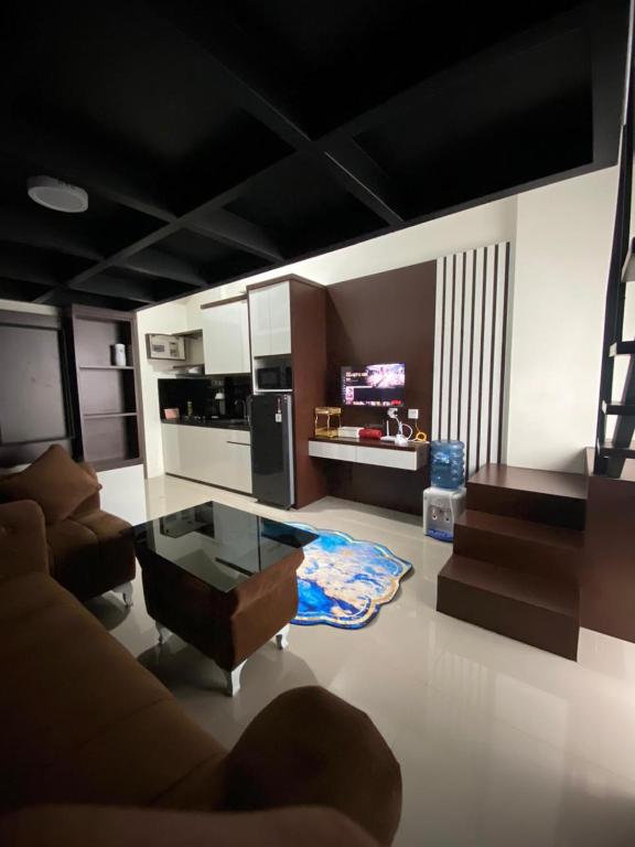 a living room with a couch and a glass table at Loft apartment bintaro in South Tangerang