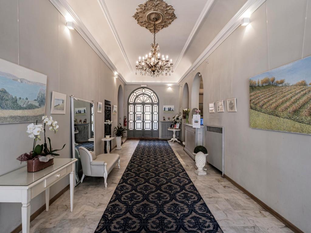 un ampio corridoio con salone con lampadario a braccio di Hotel Accademia a Bologna