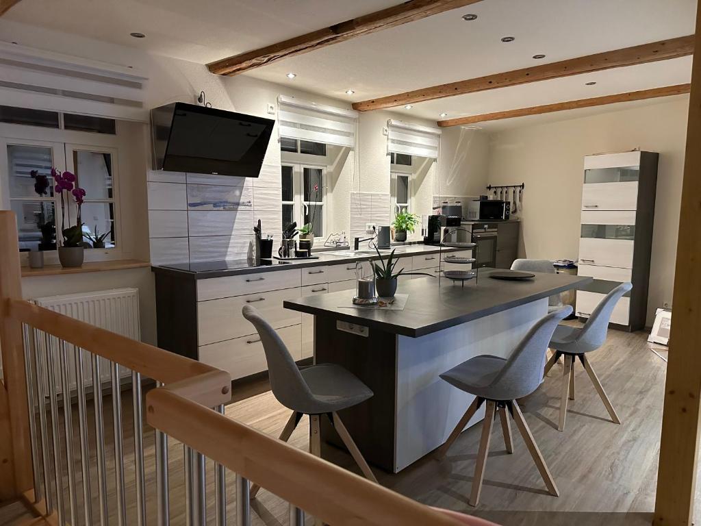 a kitchen with a large island with chairs in it at Lillis Cottage in Goslar