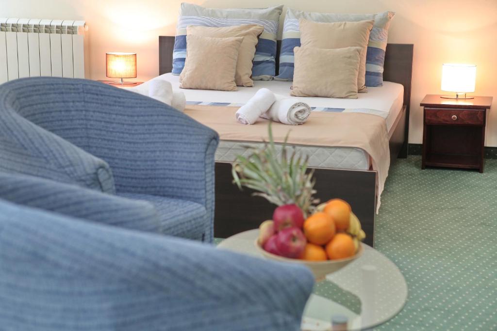 a room with a bed and a bowl of fruit on a table at Happy Star Club in Belgrade