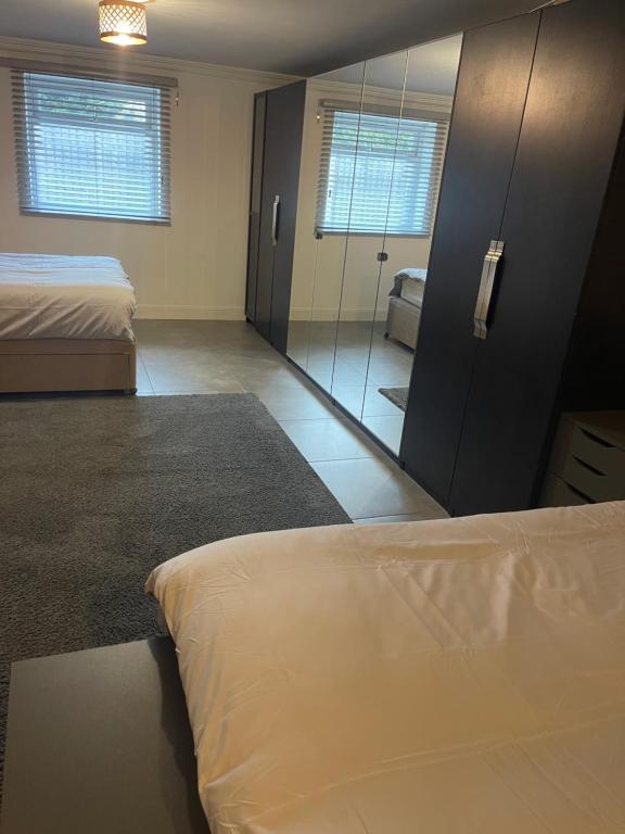 Zimmer mit 2 Betten und einem großen Spiegel in der Unterkunft 50A Green Lane in Cranford