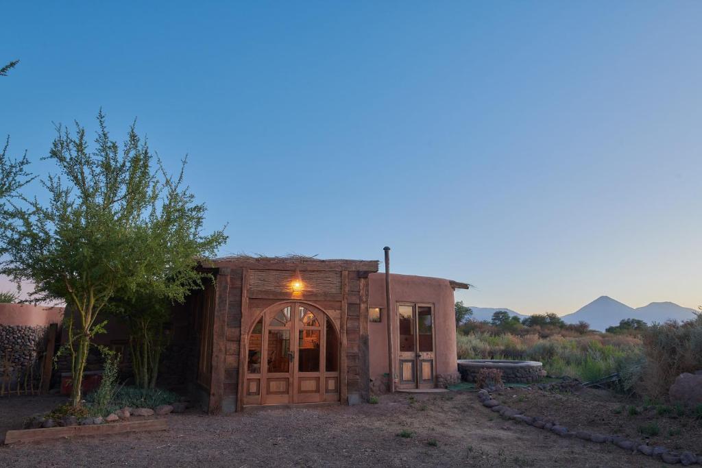 a home in the desert with a building with a door at Casa Chincol in San Pedro de Atacama
