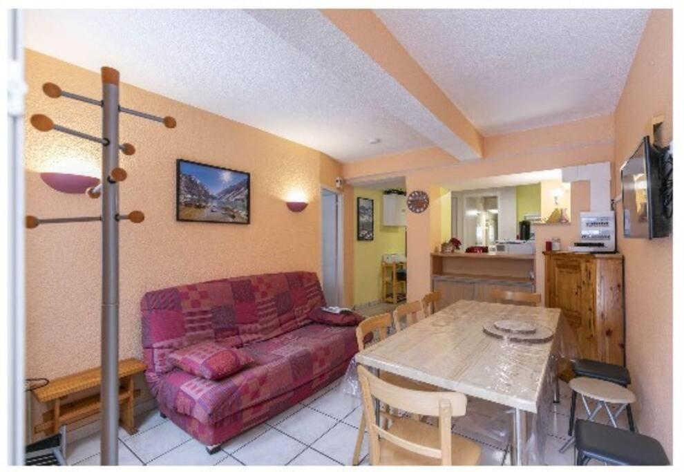 ein Wohnzimmer mit einem Sofa und einem Tisch in der Unterkunft Asphodèle, T2 bis, extérieur, wifi, parking, 6 personnes in Cauterets