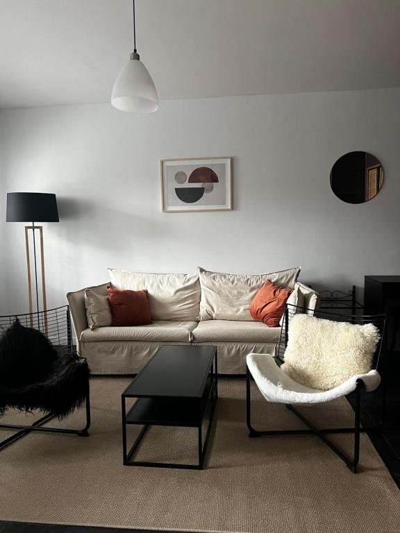 ein Wohnzimmer mit einem Sofa und einem Stuhl in der Unterkunft Apartment 202 in Gent