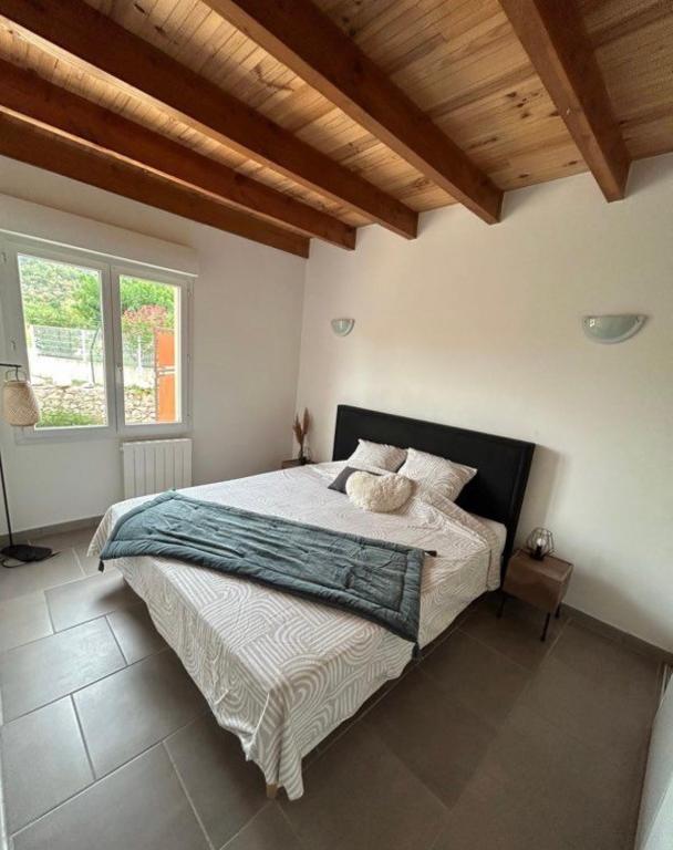 a bedroom with a large bed with a wooden ceiling at Maison piscine &amp; spa Vallon Pont d&#39;Arc in Vallon-Pont-dʼArc