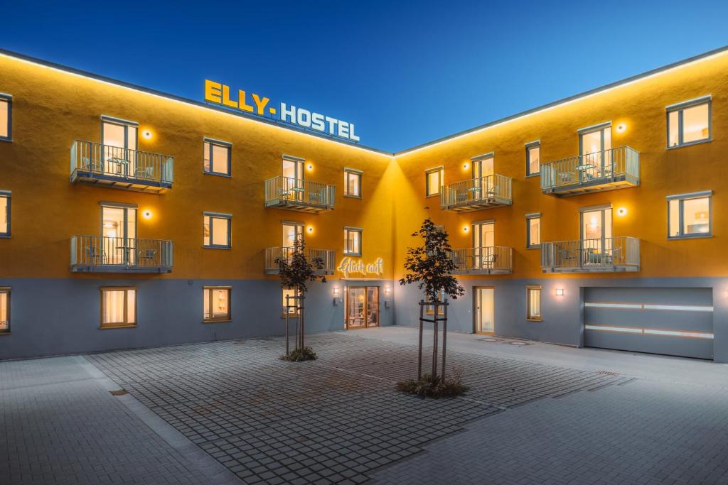 un grand bâtiment jaune avec deux arbres devant lui dans l'établissement ELLY Hostel, à Freiberg