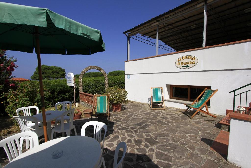 a patio with tables and chairs and a fireplace at Hotel Holiday Bambù in Marciana