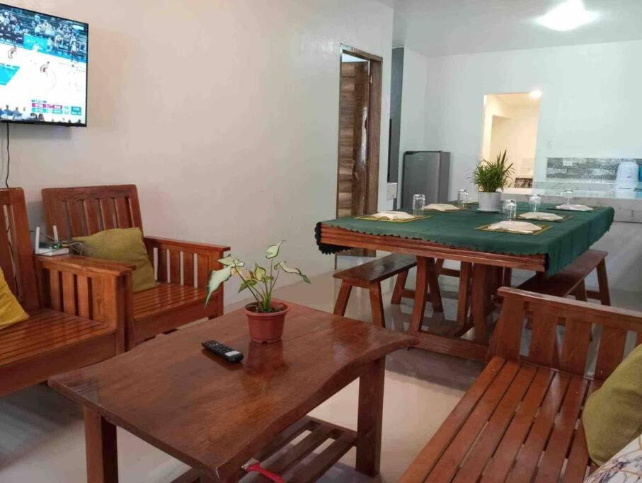 uma sala de estar com uma mesa de jantar e cadeiras em Taylors Country Home/Travellers Inn- The Bungalow em Catarman